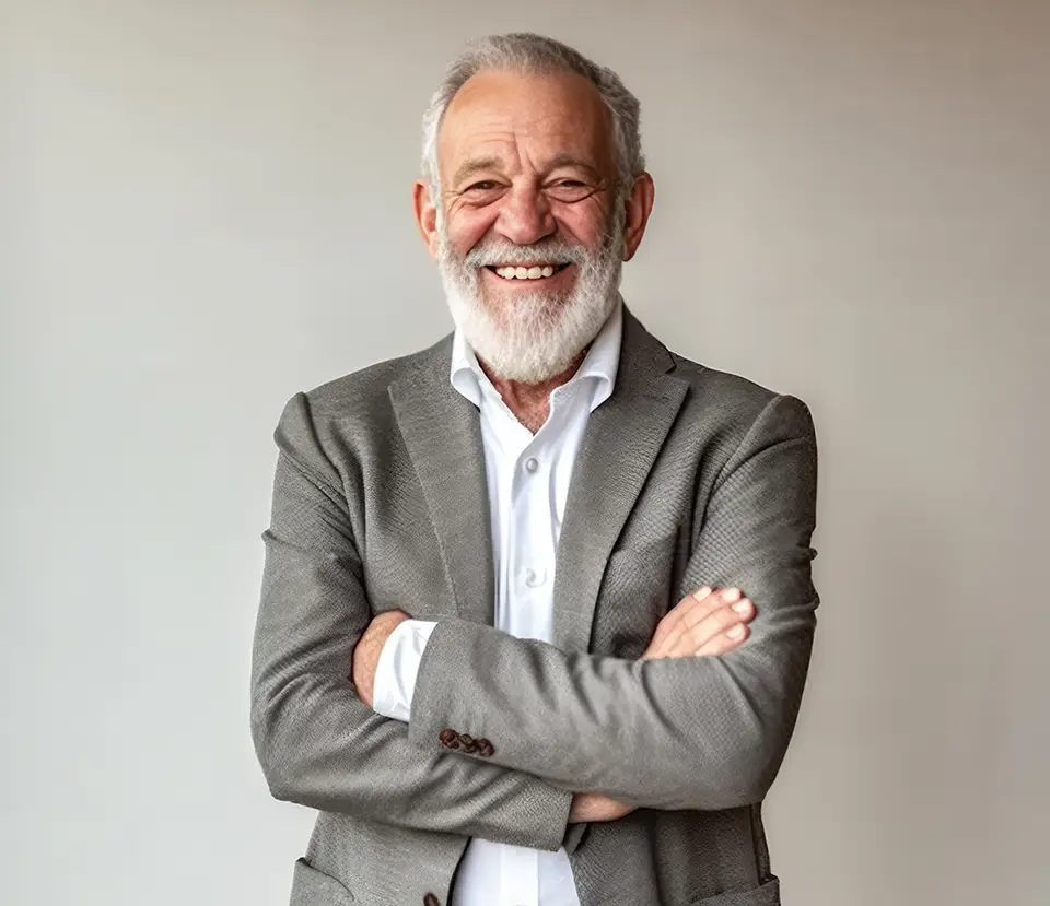 Symbolbild: lachender Mann mit weißem Bart im grauen Sakko – Stimme eines Unternehmens zu Fachkräften im Ruhestand über Sentaris