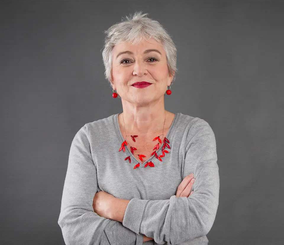 Symbolbild: Frau mit grauem Kurzhaar und roter Kette – Stimme einer Bezirksleiterin, die über Sentaris eine Expertin im Ruhestand fand